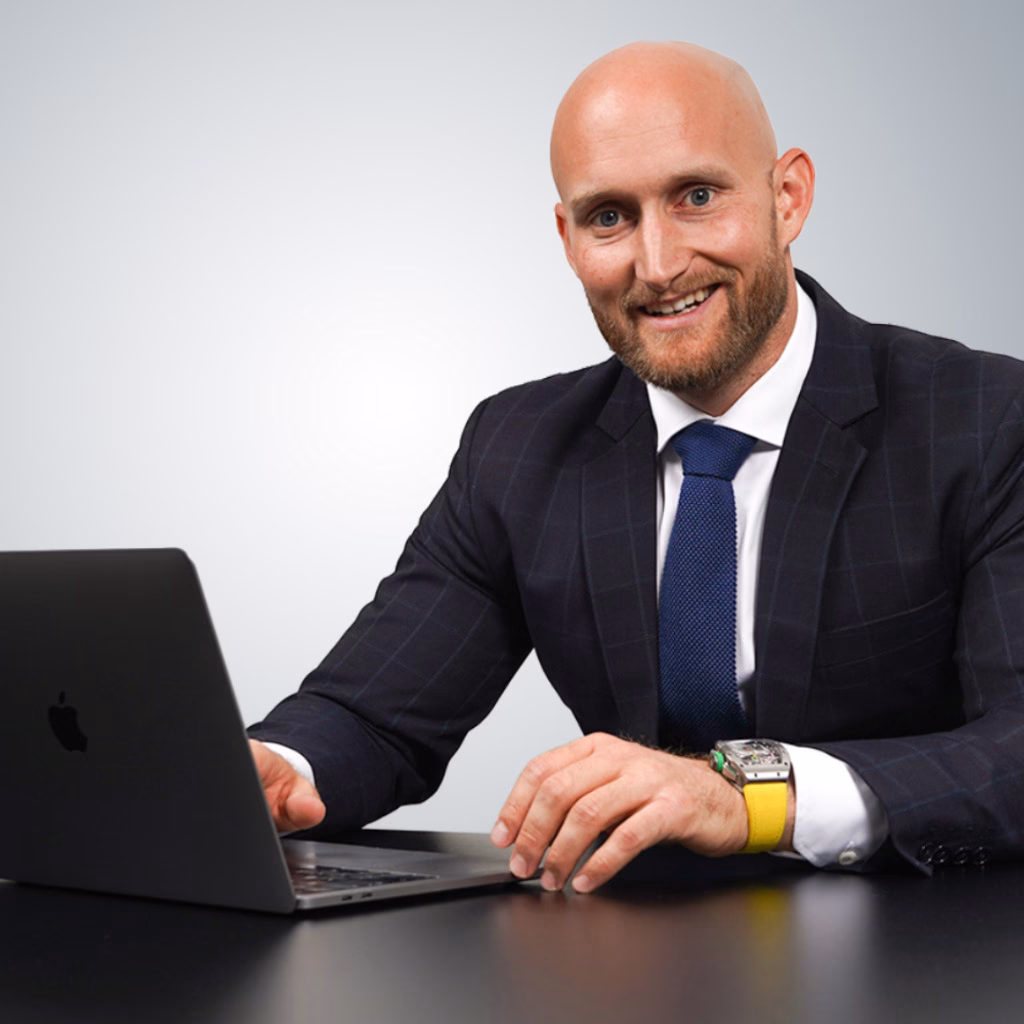 Der Unternehmer Karl Ess im Anzug vor einem Laptop